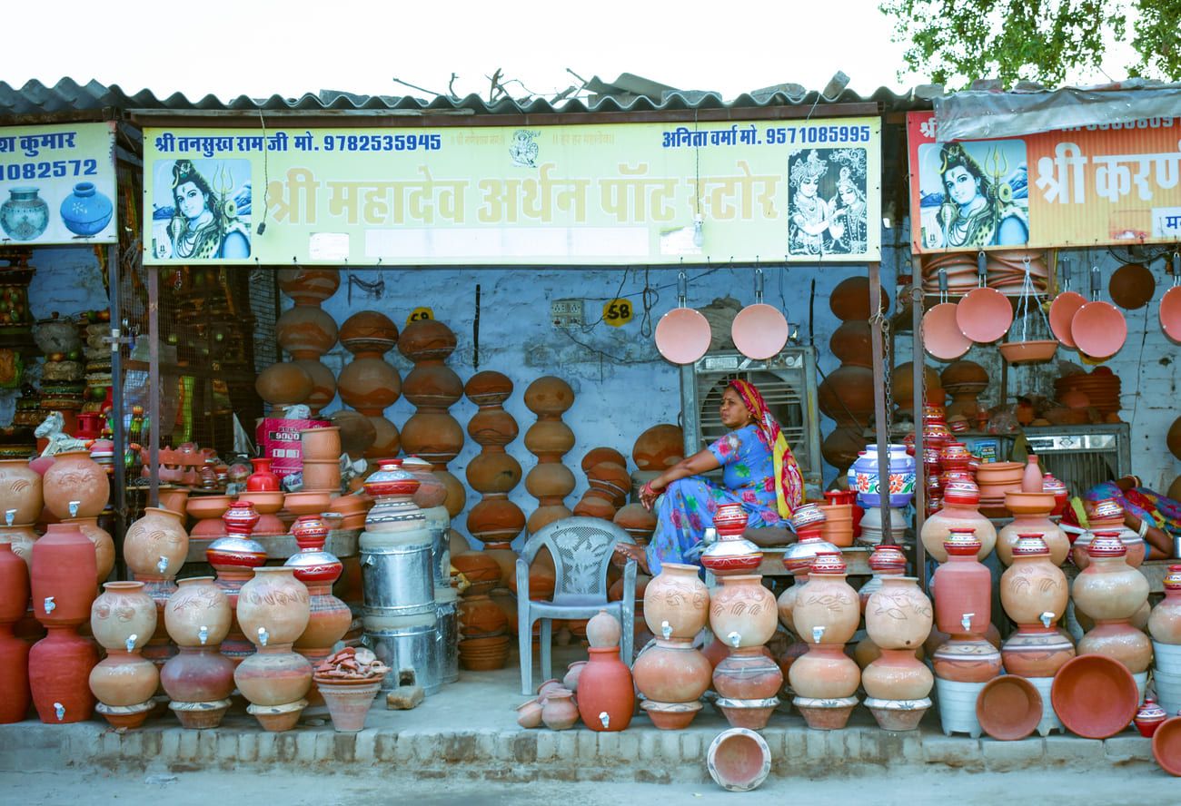 A vendor at her stall selling water vessels