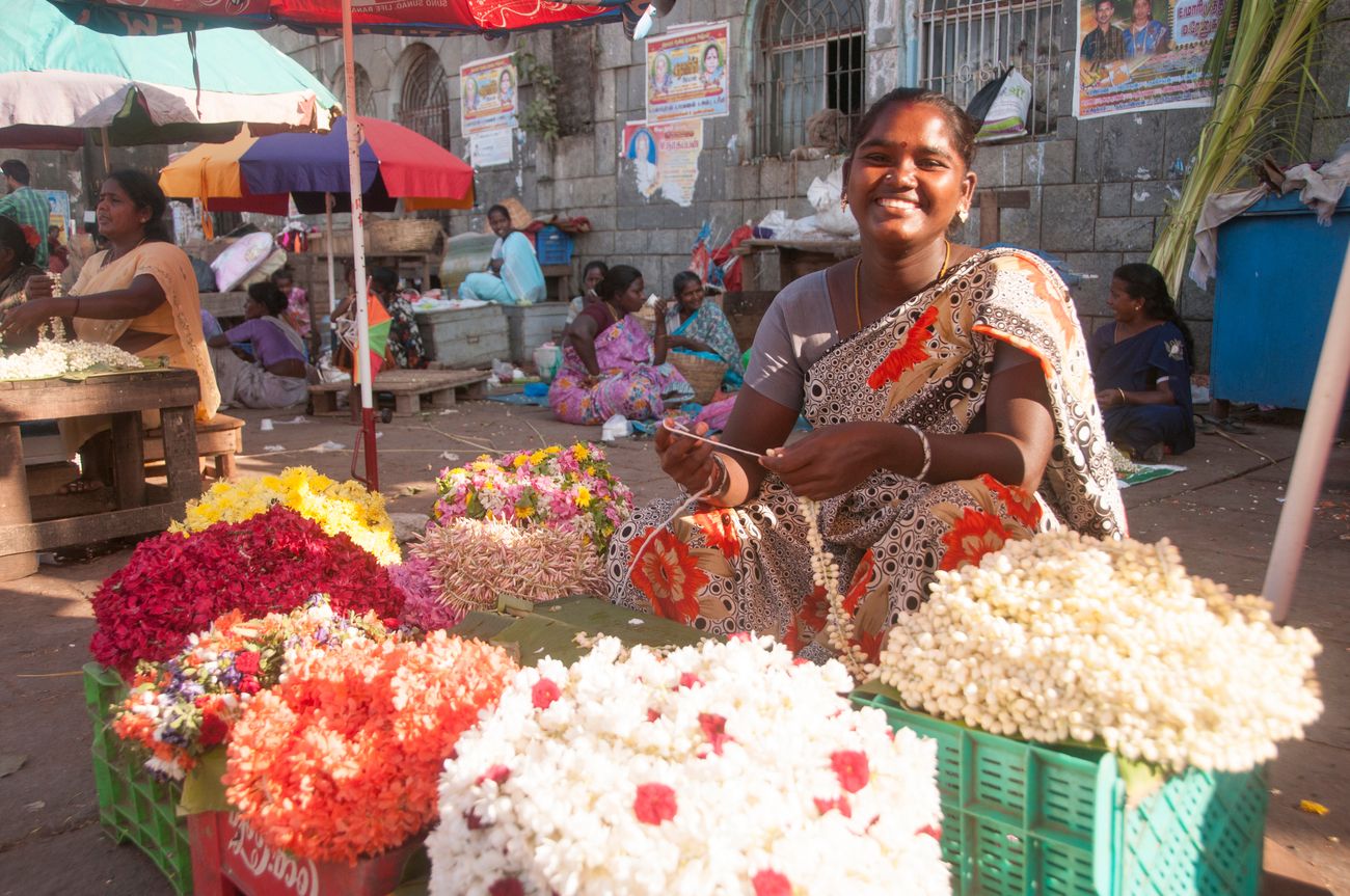 A woman in Chennai’s flower market, the largest of its kind, happily selling her colorful bunches of flowers