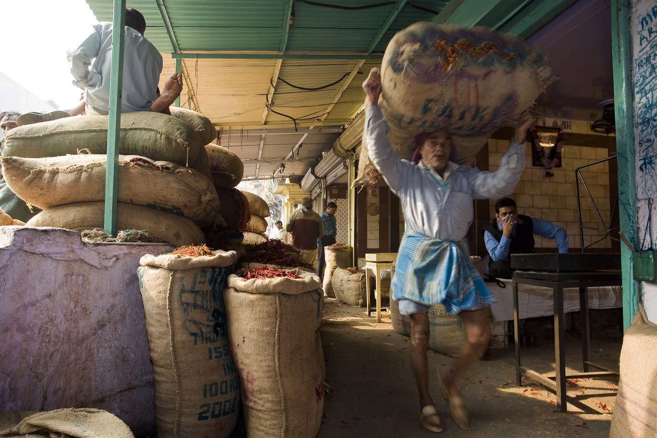 A worker with a bag of spices at the spice market in New Delhi, India
