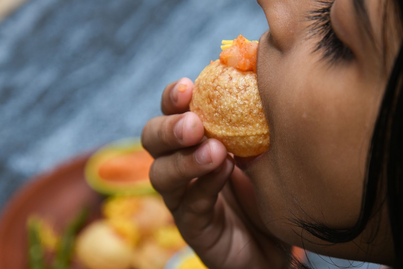 A young girl eats paani puri, a beloved Indian street snack with endless variations across the country