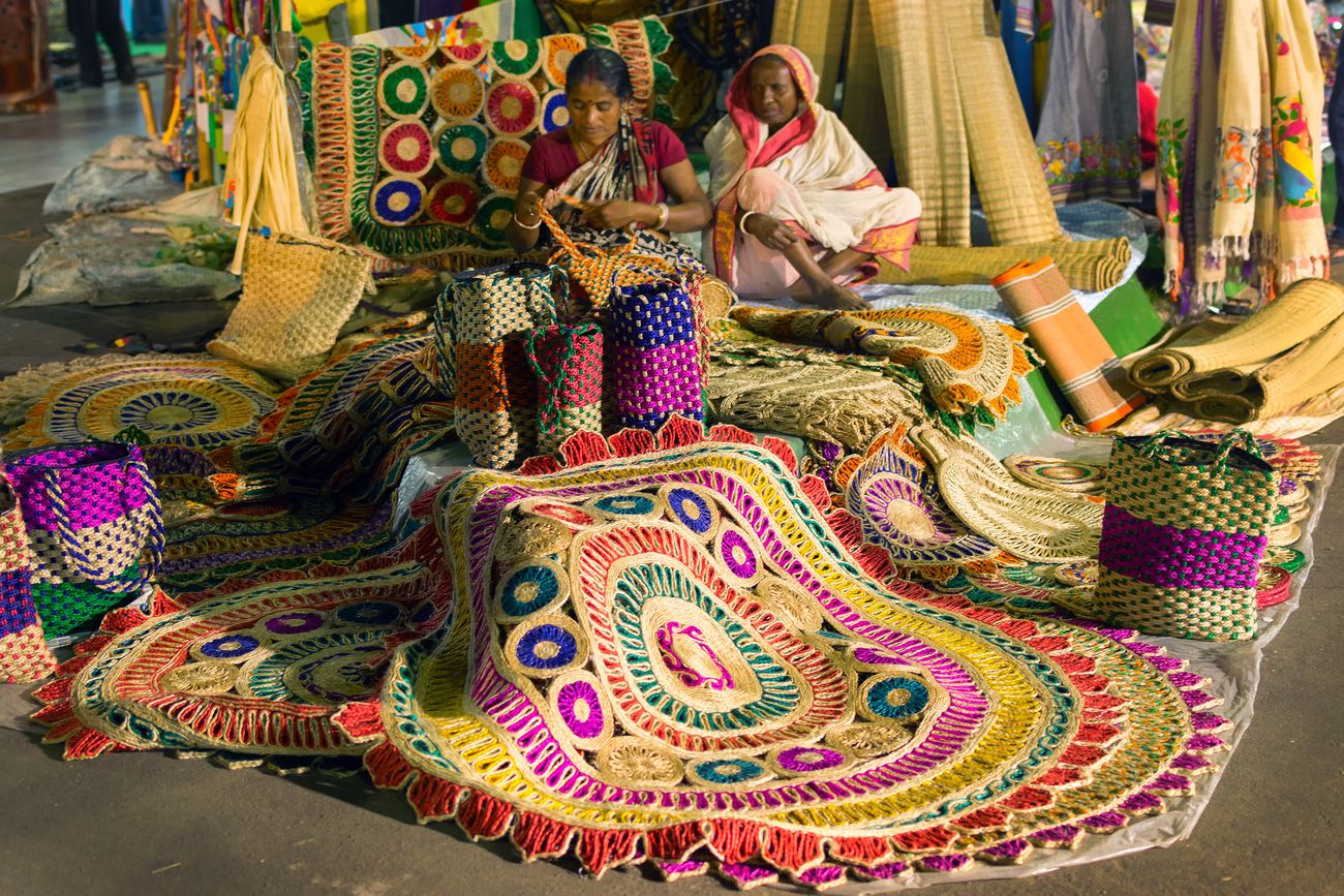 Women at Asia’s largest handicrafts fair in Kolkata preparing traditional handicraft artworks such as jute bags and carpets 
