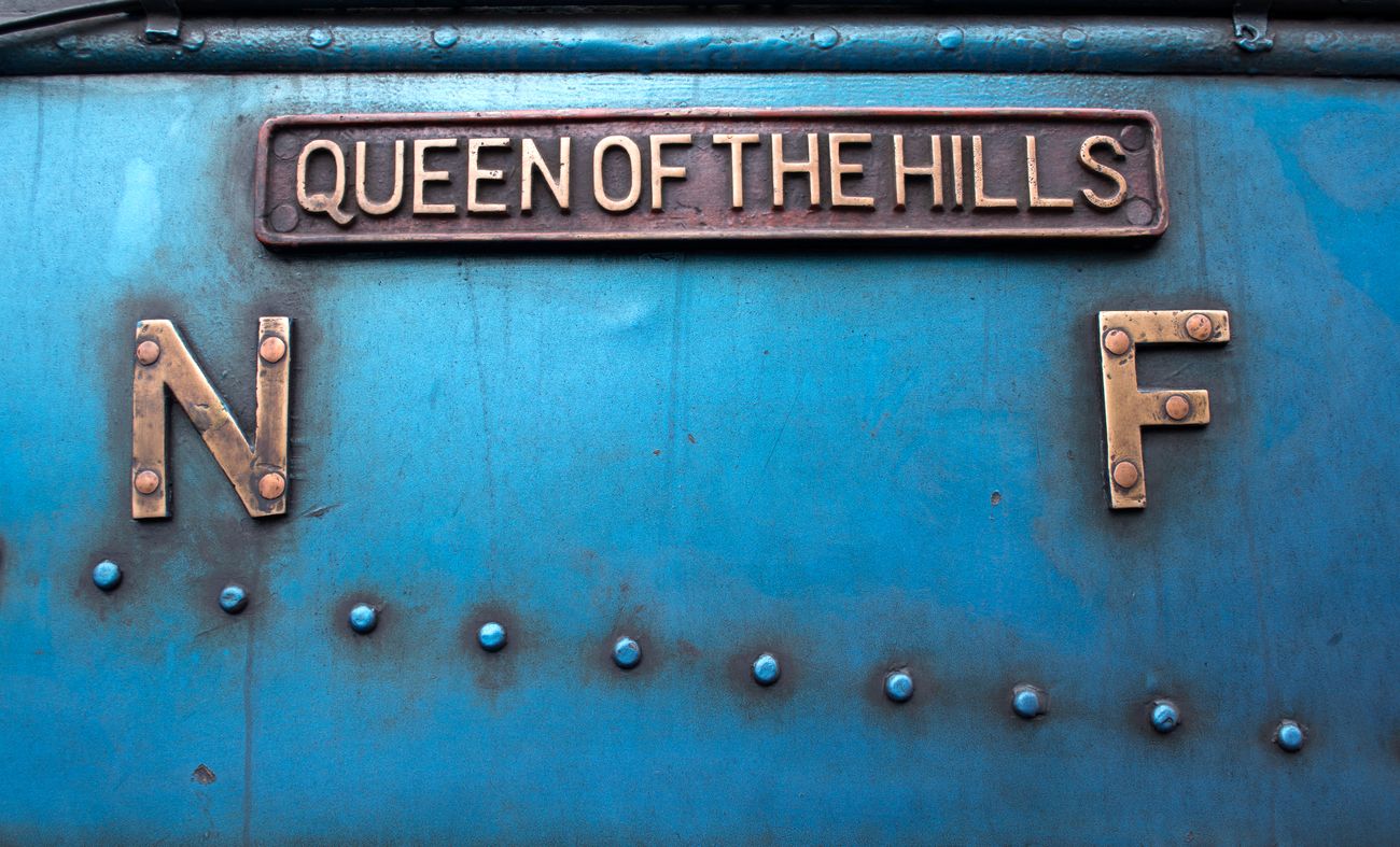 A close up shot of the sign on the Toy Train saying ‘Queen of the Hills’ which is the pet name of the Darjeeling Himalayan Railway 