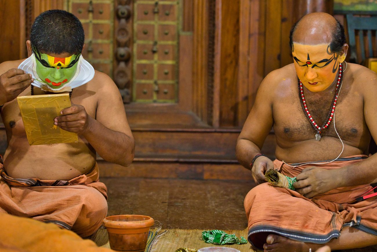 Dancers paint their faces in preparation for their Kathakali dance performance, a classical Indian dance form that incorporates traditional warrior martial arts movements.