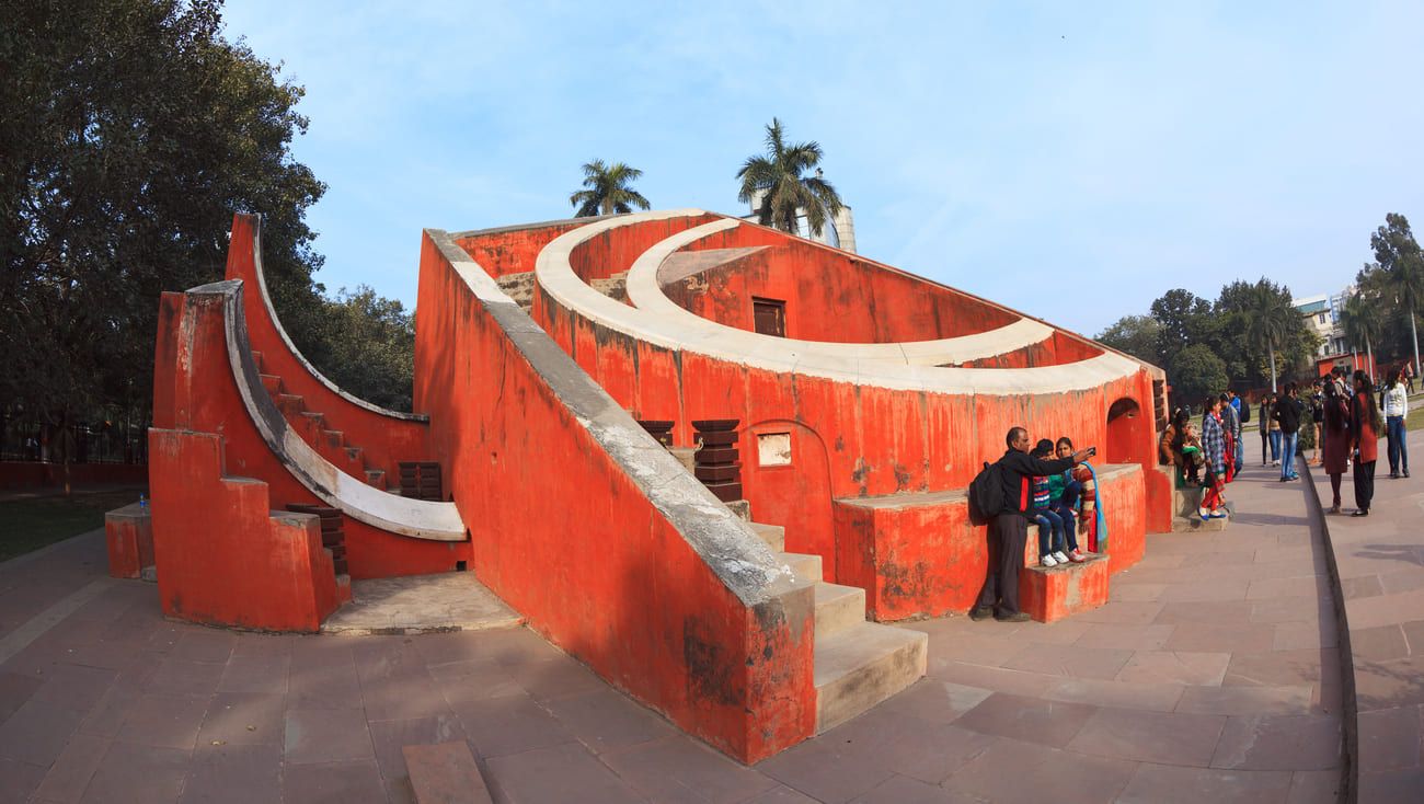 Indian family taking a selfie in front of Misra Yantra, one of the astronomical instruments of the Jantar Mantar observatory in New Delhi, India 