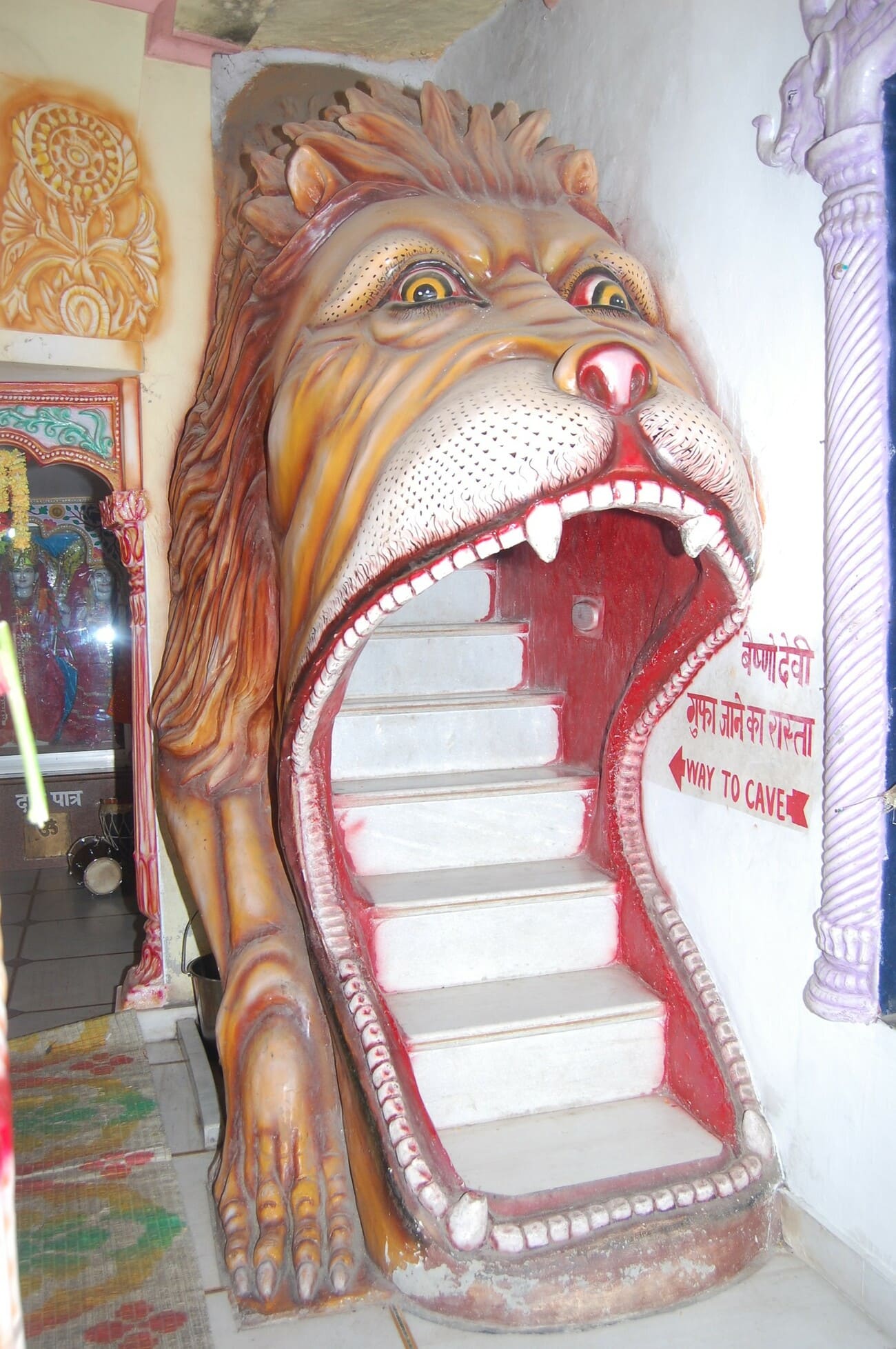 A brightly colored lion’s head forms the entrance to steps leading up a temple in Bhagsu 