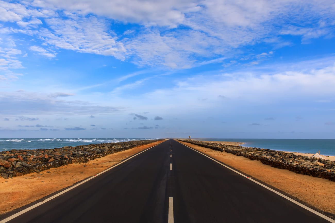 Long straight road seemingly disappears into the sea. On one side is the Bay of Bengal with the waters of the Indian Ocean on the other side, Dhanushkodi 