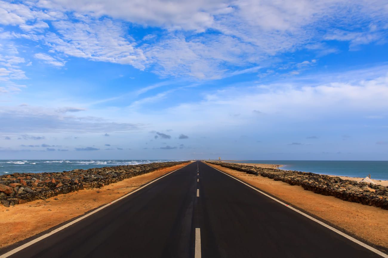 Long straight road seemingly disappears into the sea. On one side is the Bay of Bengal with the waters of the Indian Ocean on the other side, Dhanushkodi