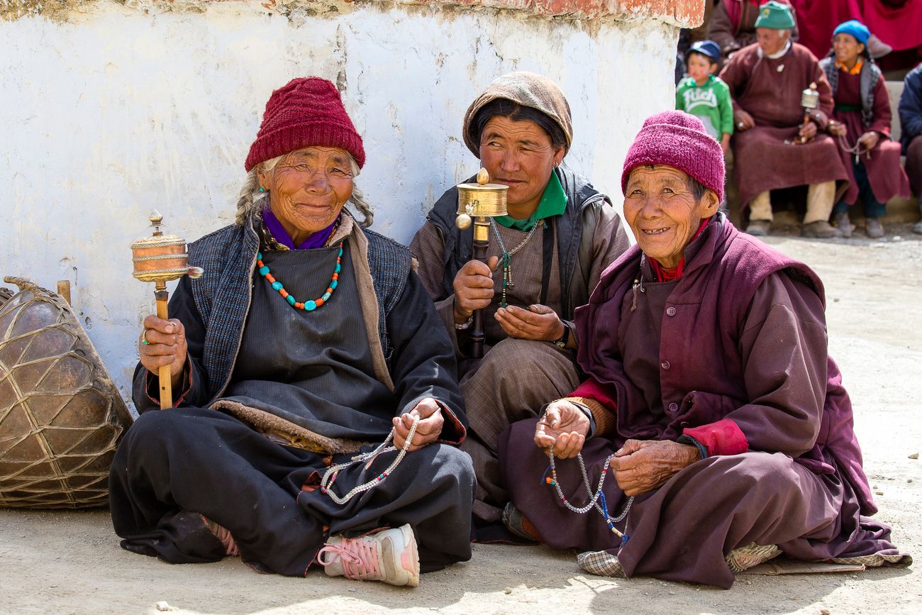 Old Buddhists sitting during mystical mask dancing called Tsam during the Yuru Kabgyat Buddhist festival at Lamayuru Gompa, Ladakh 