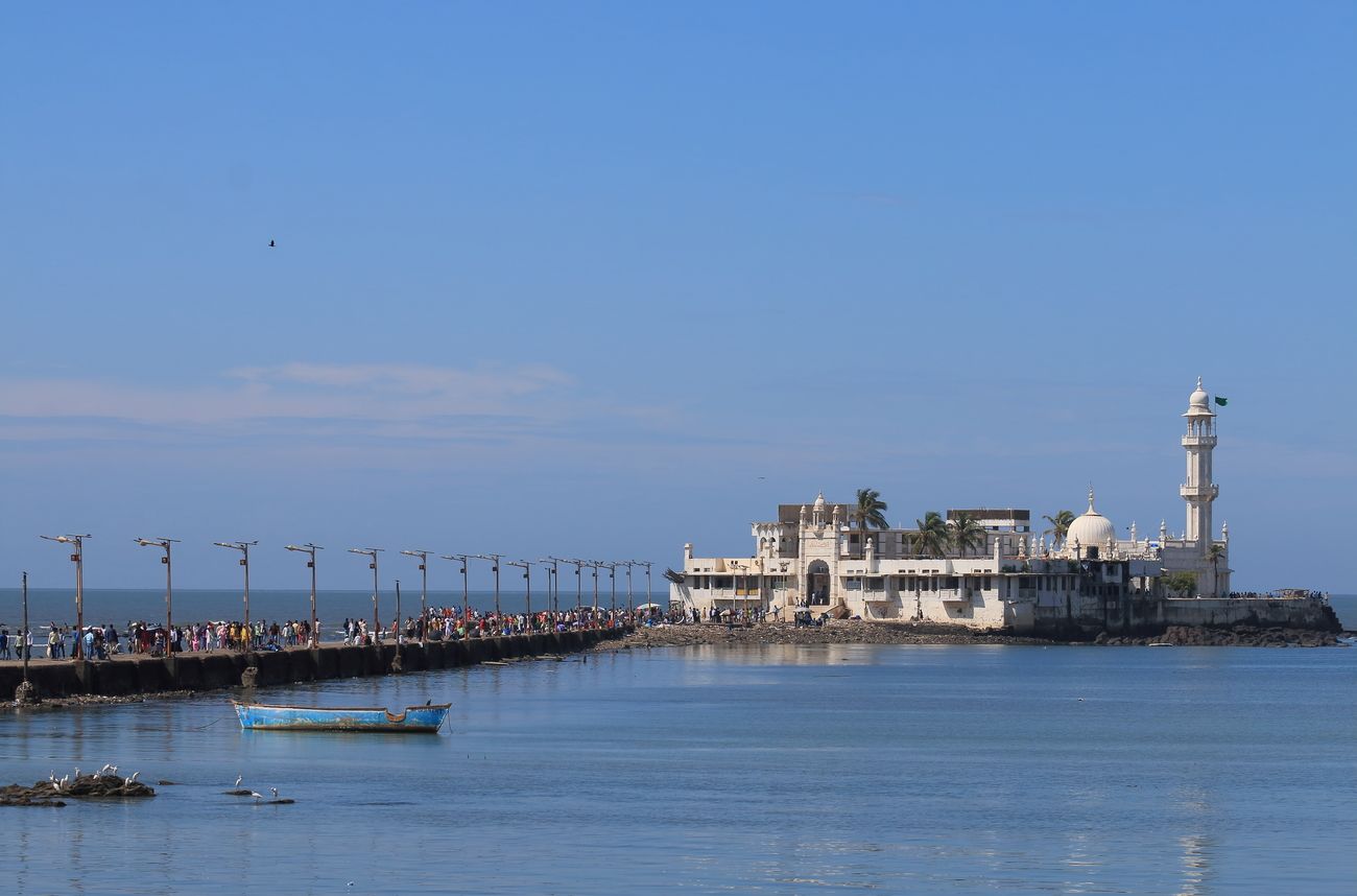 One of Mumbai's most prominent landmarks, the Haji Ali Dargah (Mosque) is situated in the middle of the sea and is named after Pir Haji Ali Shah Bukhari, one of the greatest Muslim saints of his time. Built on a tiny islet located 500 yards in the middle of Worli Bay, the dargah can be visited only during low tide 