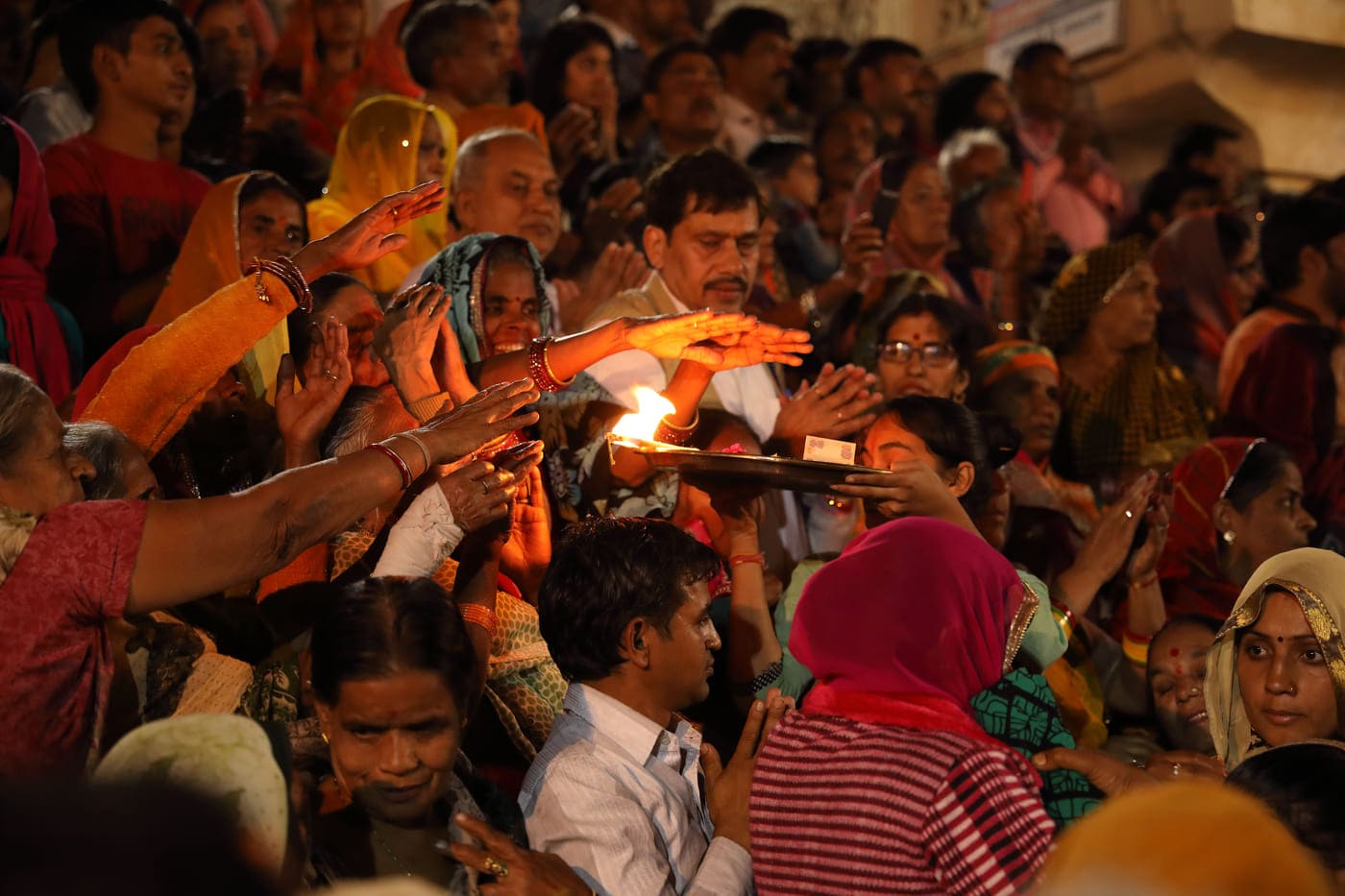People throng around the priest to receive the Maha Aarti blessing at the Varaha ghat. It is customary to offer the priests compensation in the form of a small amount of money at such occasions
