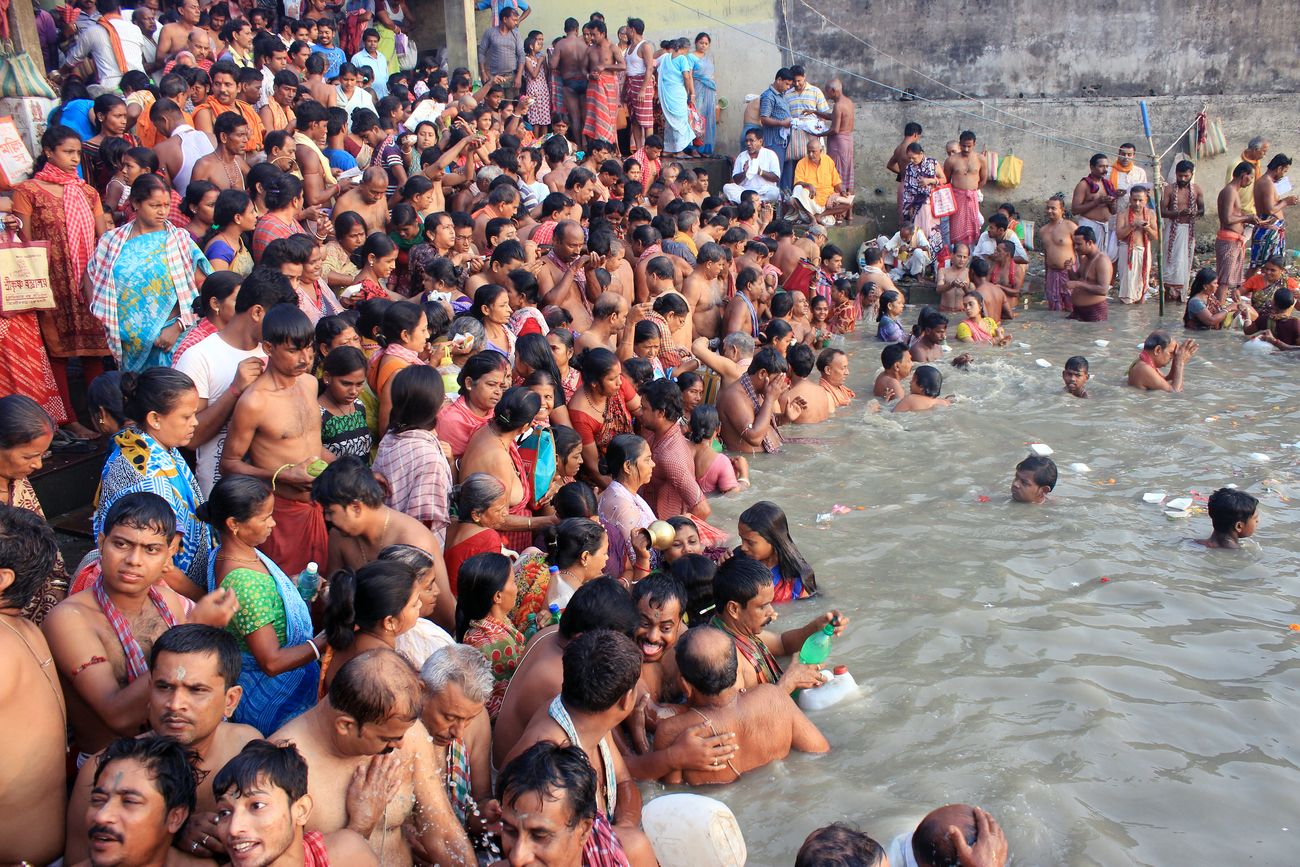Pilgrims on the banks of Hooghly river in Kolkata enjoying a holy dip and offering prayers