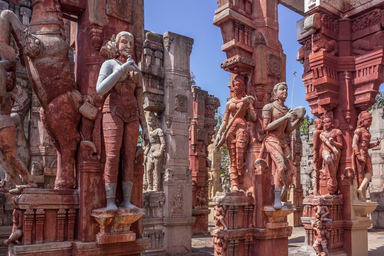 Red dusted statues of a woman holding a parrot in her hand, musicians with their instruments, a rearing horse and female dancers forms part of this ancient structure