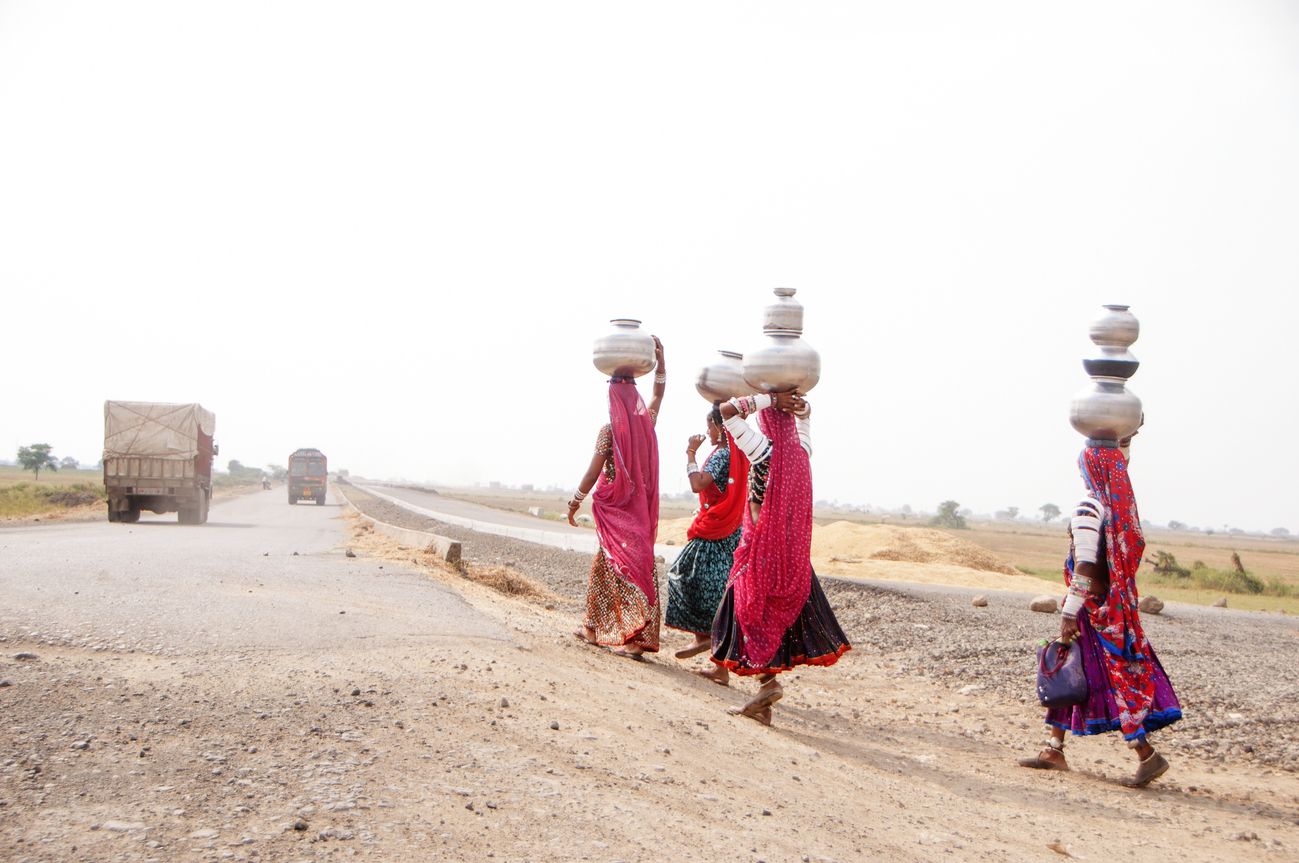 Rural women walk through the desert to carry water in earthen pots to their houses - several kilometers every day - due to the drought which plagues the area Being close to Kutch, Mandvi is a good place to experience the colourful costumes and unique lifestyle of the rural pastoral communities