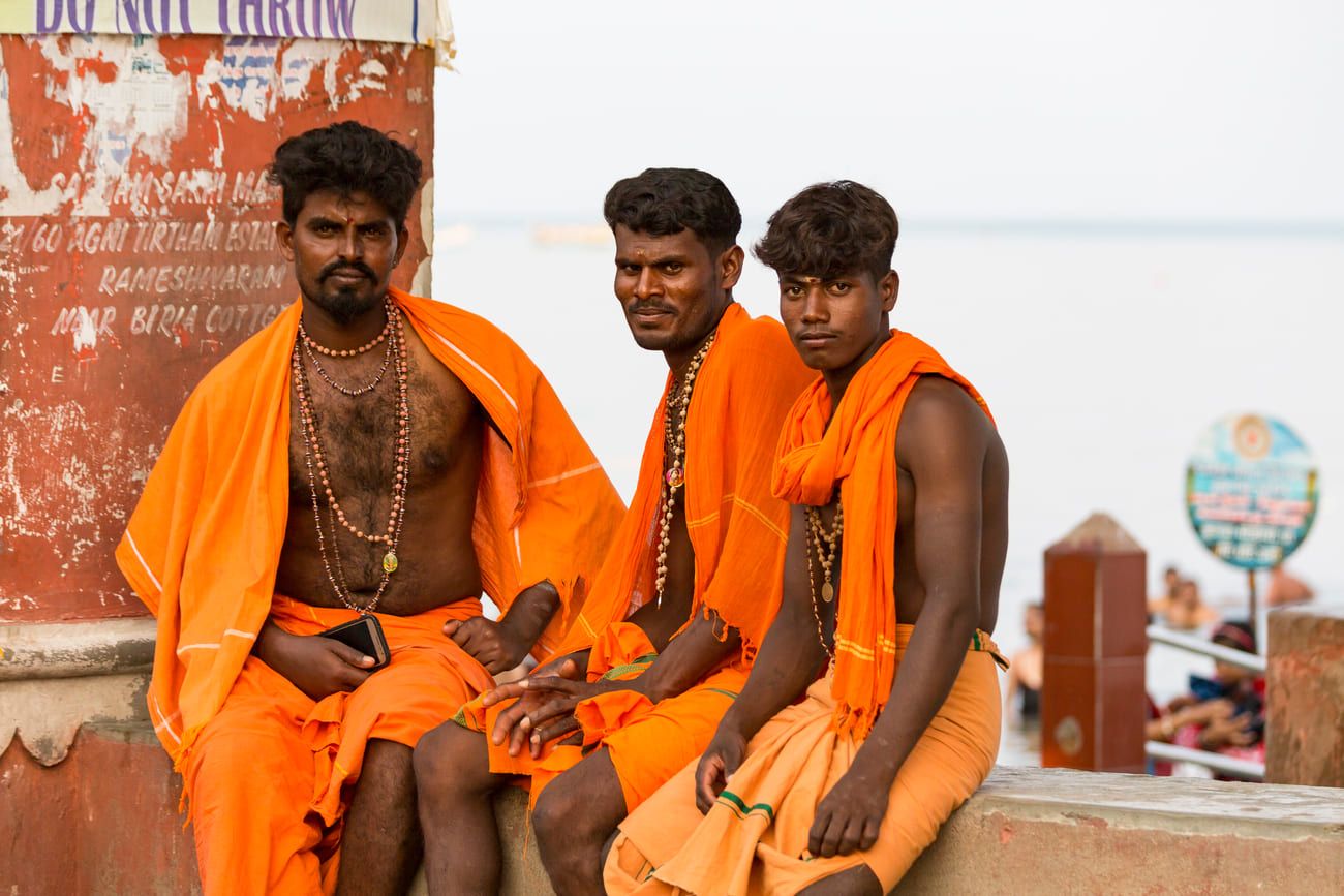 Sadhus pilgrims in their distinctive deep orange clothes. During this important pilgrimage devotees bathe in the sea to cleanse themselves of transgressions 