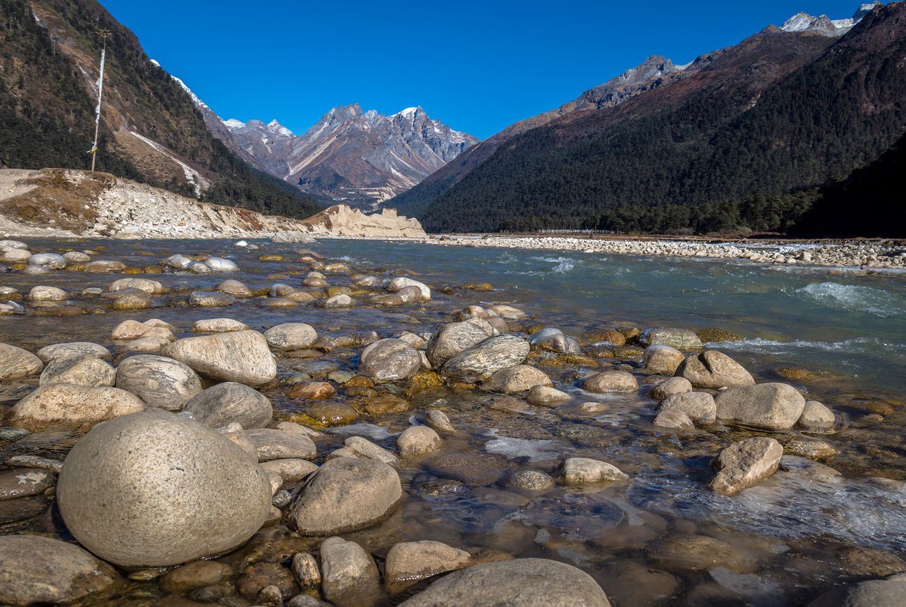 The pristine Teesta river flowing through the Yumthang Valley, softening the edges of river stones, is one of the most popular postcard images from the valley