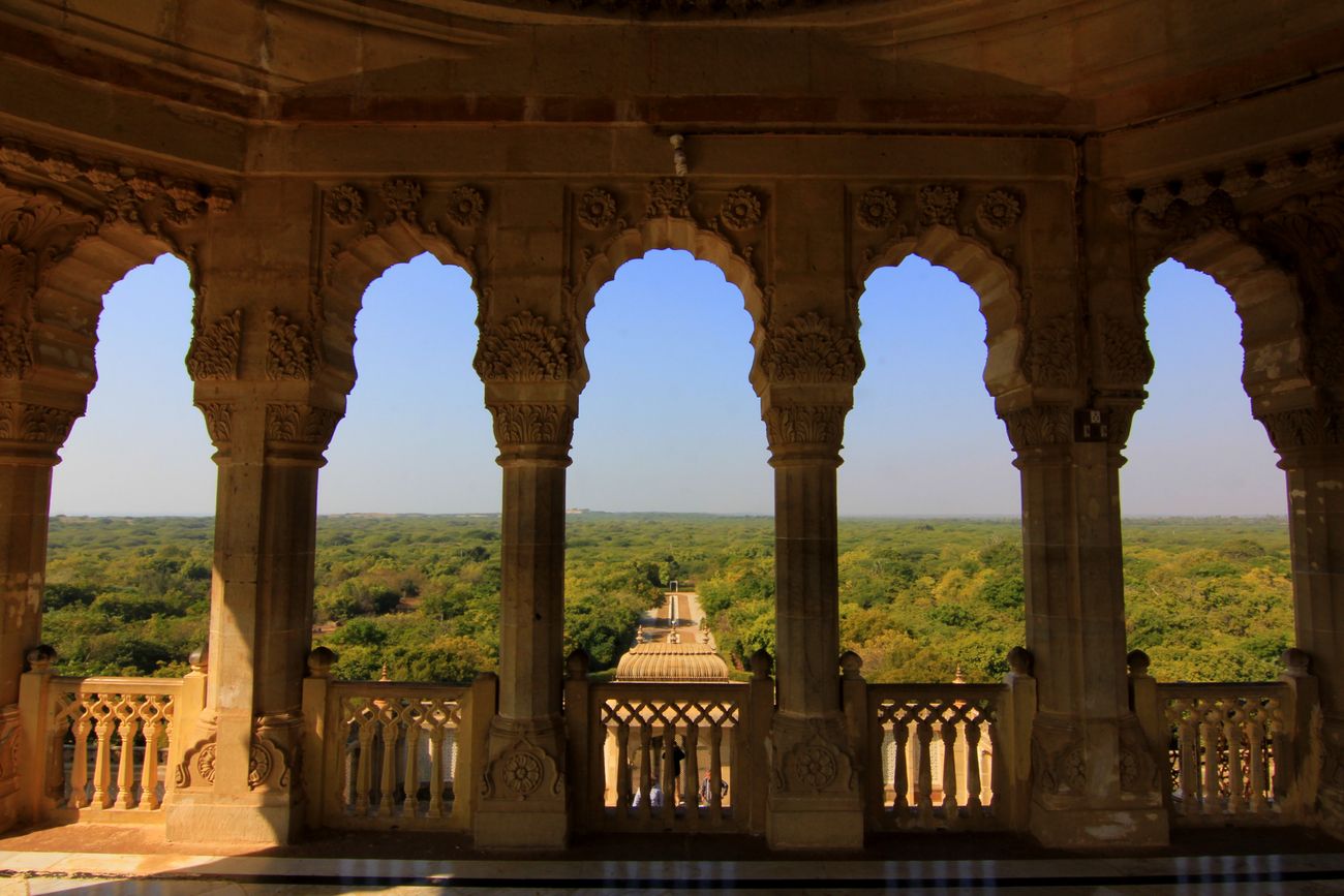 The regal balcony of the Vijay Vilas Palace is made with acrved Red Sandstone, looking over the vast spans of vegetation that surround the palace