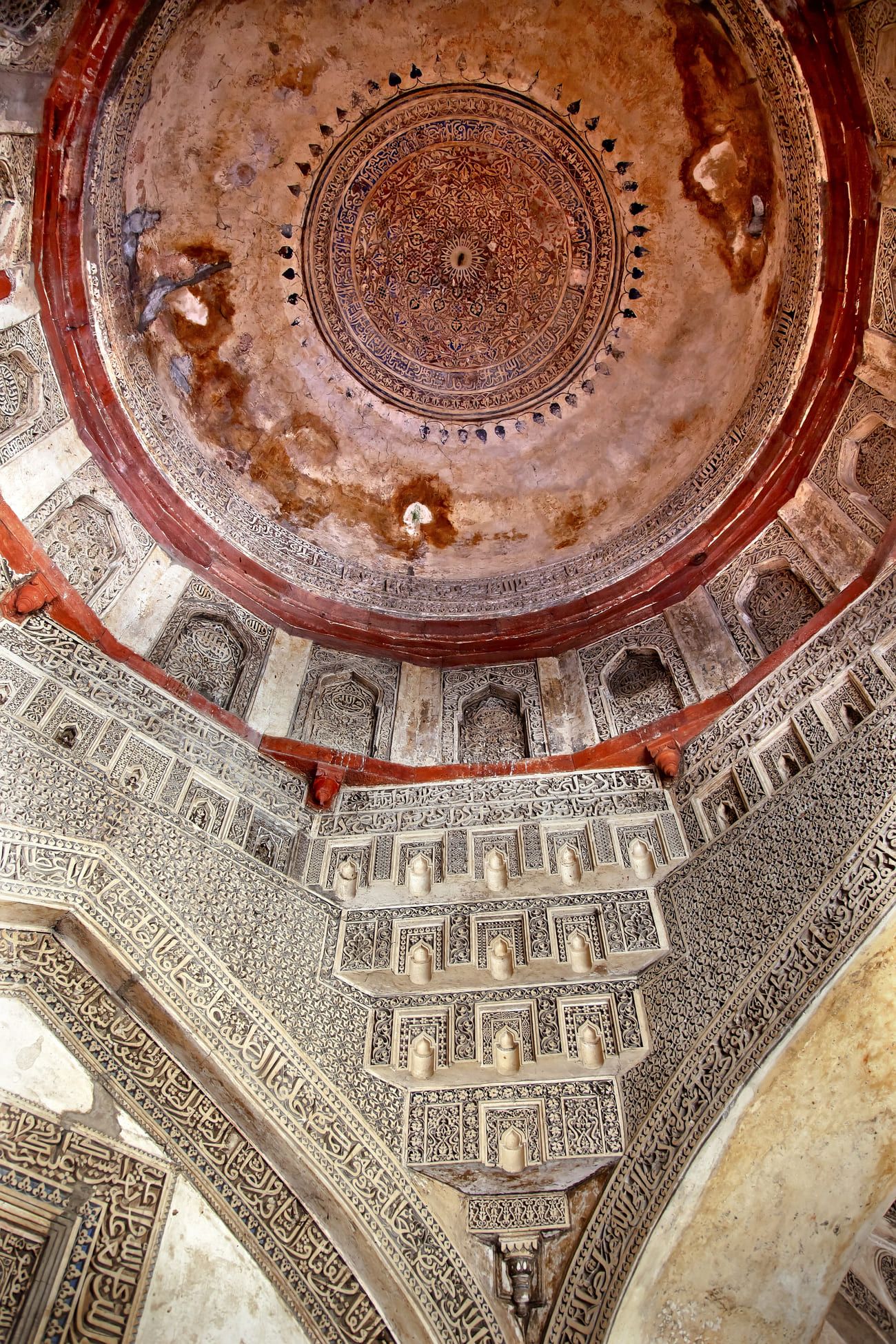 The richly decorated ancient dome inside the huge Sheesh Shish Gumbad Tomb at Lodi Gardens in New Delhi, India 