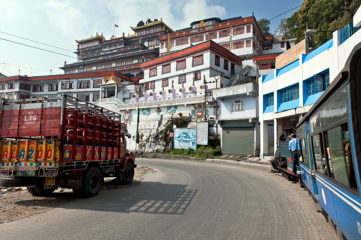 The Darjeeling Toy Train turns left alongside the highway while crossing the Yiga Choeling monastery of Ghum