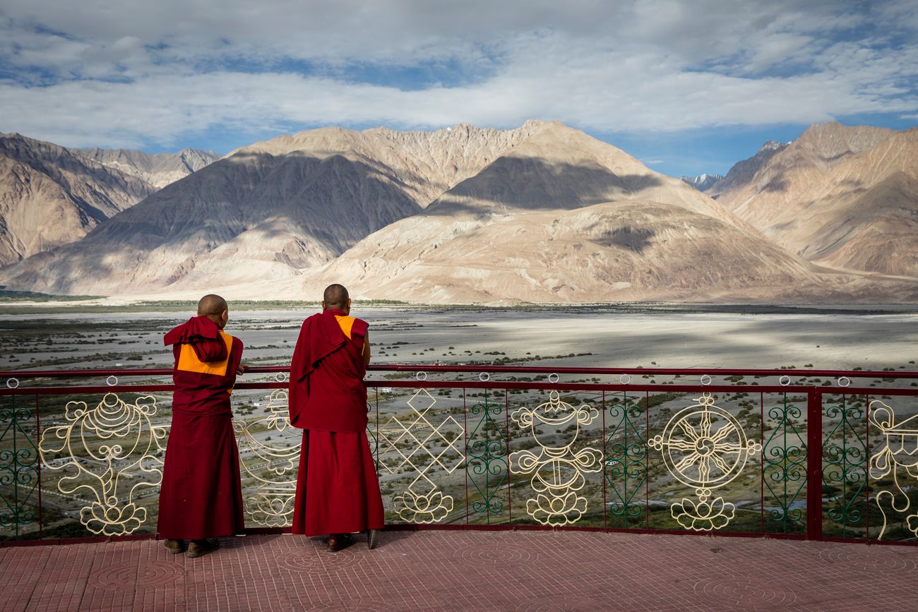 Two monks stand and overlook the Nubra valley in Ladakh from the Diskit Monastery 
