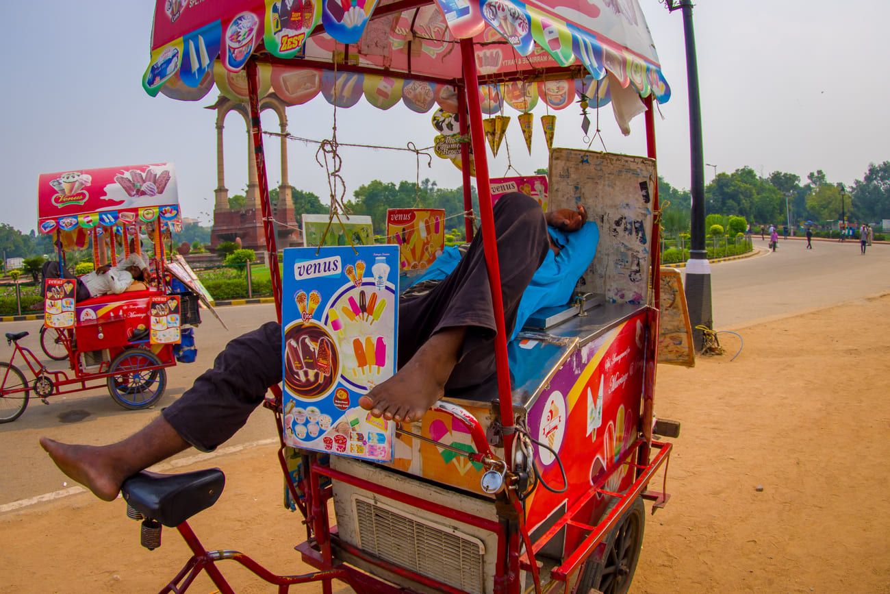 Vendors of ice-cream and cold drinks relaxing on their colorful carts at the Gate in Delhi, India 