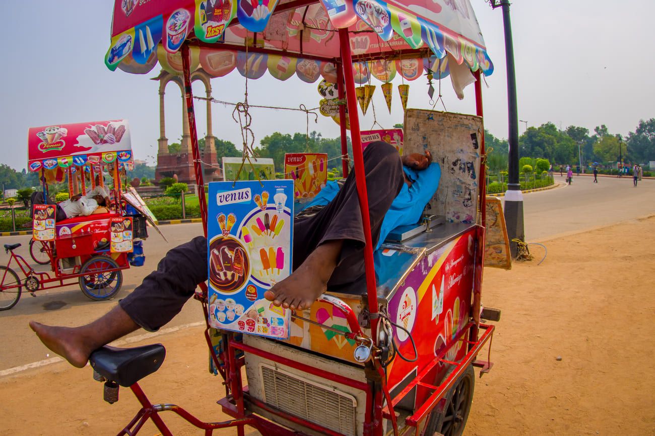 Vendors of ice-cream and cold drinks relaxing on their colorful carts at the Gate in Delhi, India