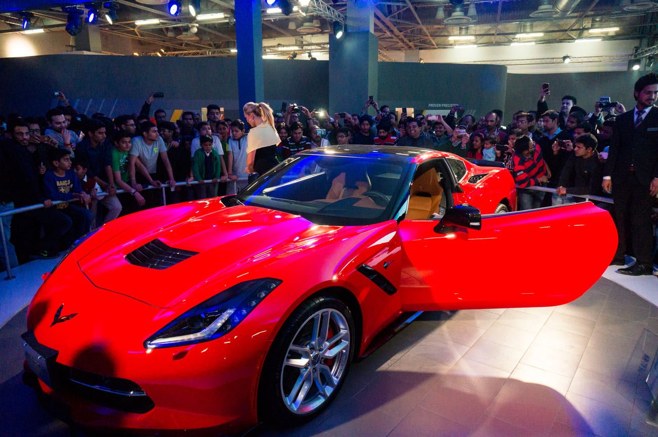 Visitors admiring the red Chevrolet Corvette, one of the main attractions at the Delhi Auto Expo in 2016 