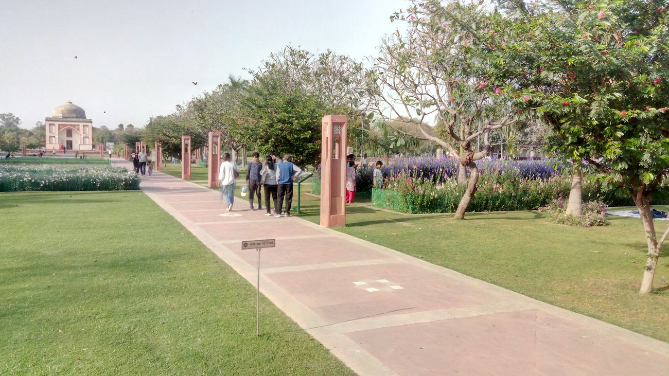 Visitors look at the colourful flowers that blossom on bushes and trees in the Sunder Nursery during Spring time in New Delhi 