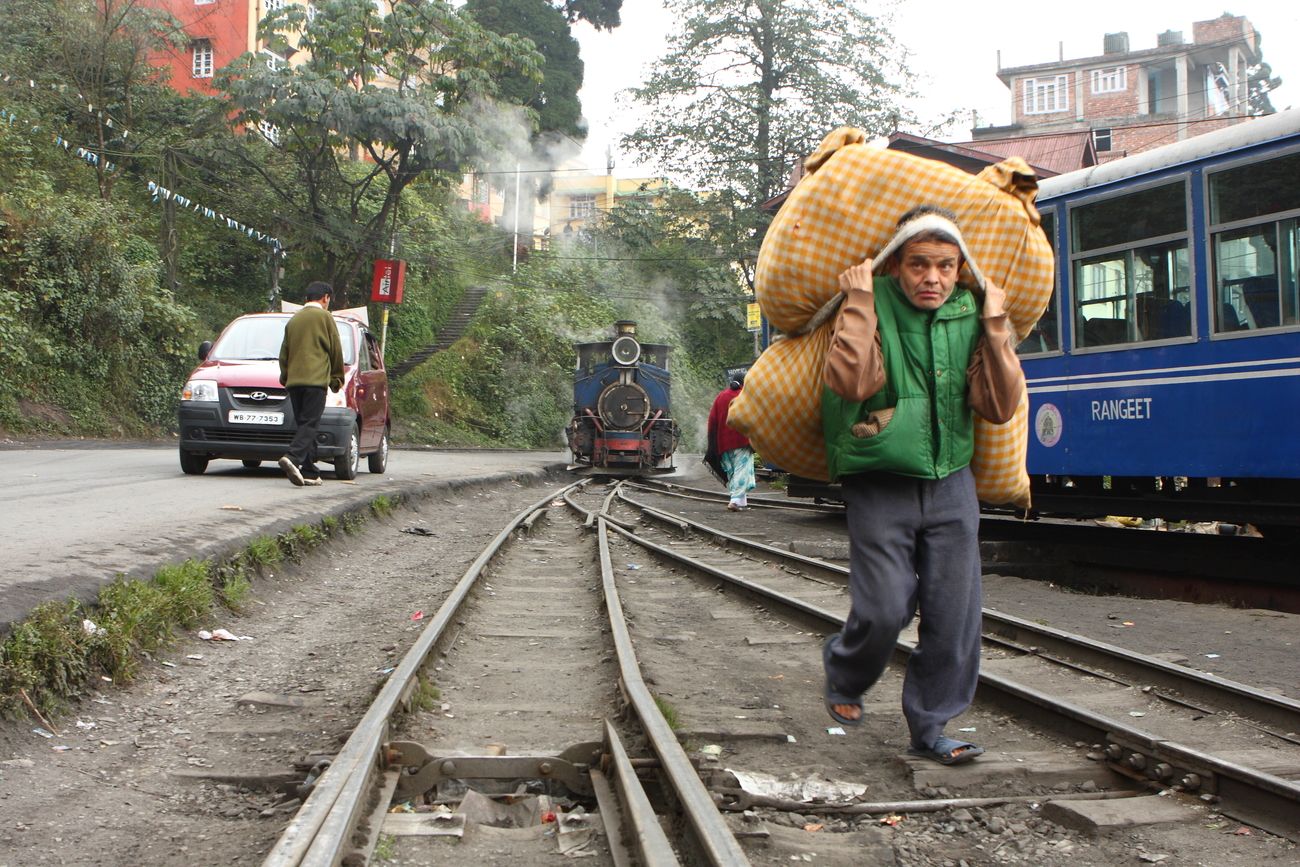 With railway tracks next to the main roads during much of its course, the Darjeeling Toy Train often travels parallel to cars, and is parked on the roadside too! 