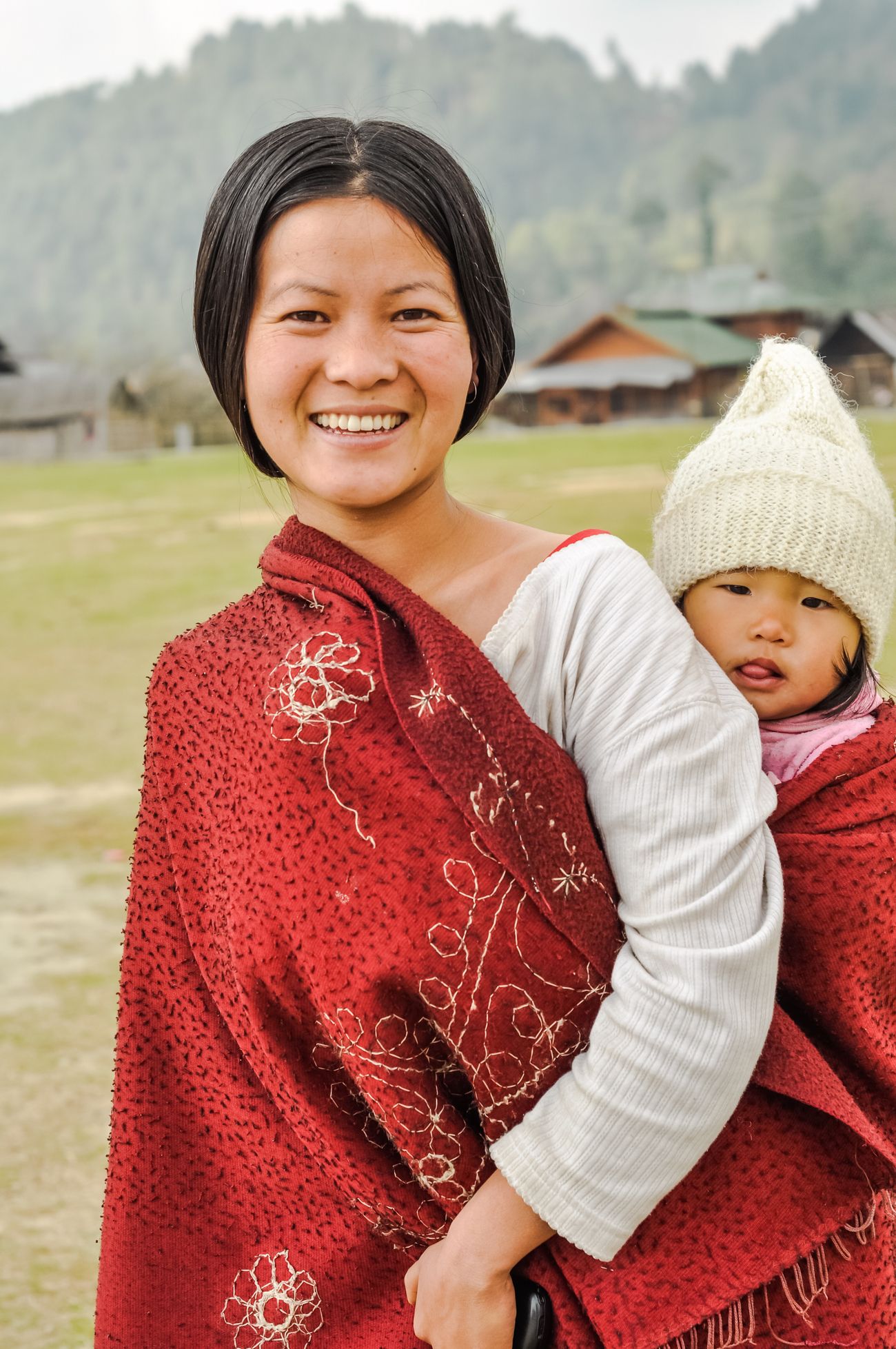 The Apatani in Ziro women are said to be blessed with beauty which is quite evident from the picture of a young woman in a white t-shirt and red scarf carrying her daughter on her back at Ziro, Arunachal Pradesh