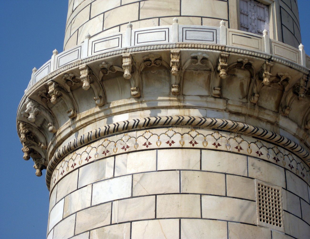 closeup of minaret with semi precious stone inlay work and carved balcony