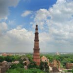aerial view of qutub minar and surrounding monuments in mehrauli archaeological park