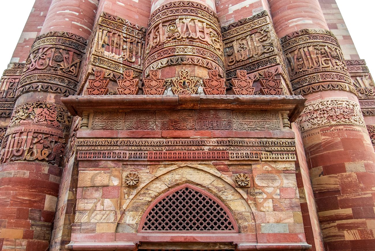 islam mosque and columns of qutub minar. red sandstone. verses from the quran51