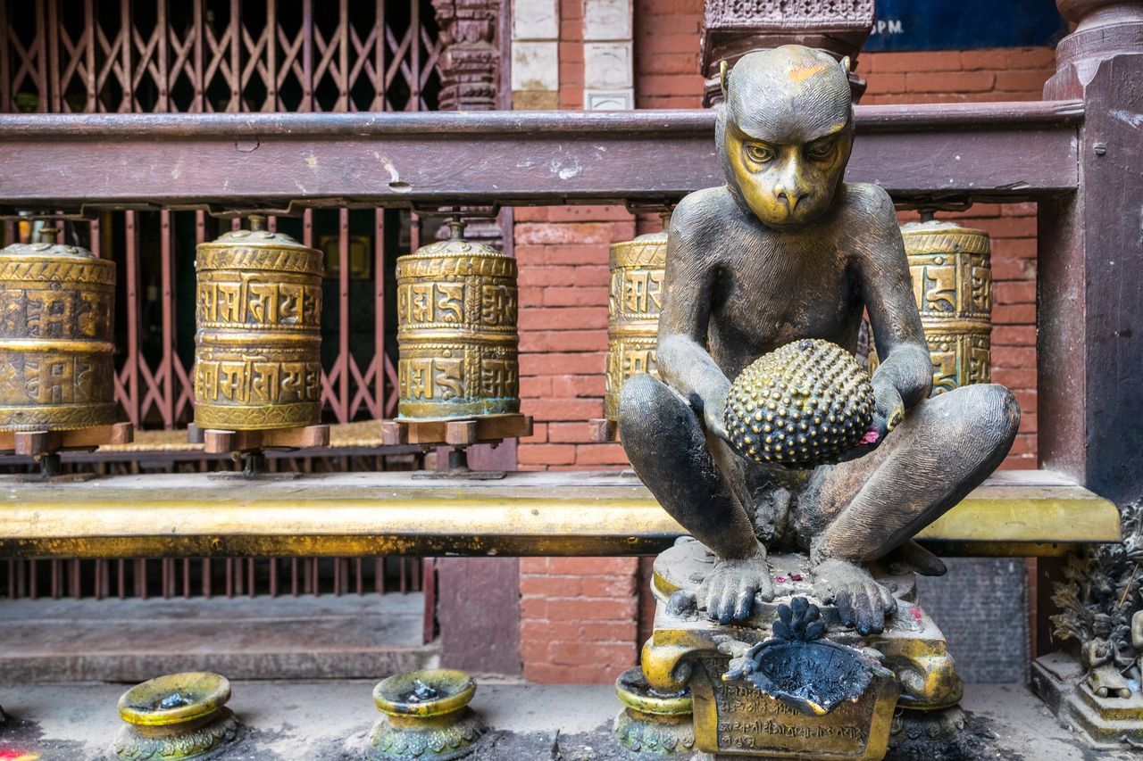 Prayer wheels cylinders golden sculpture of monkey in holy hindu temple kathmandu