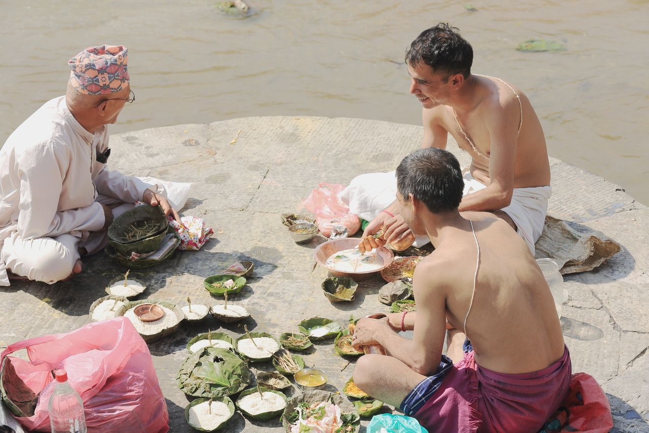 Bhatta priests receive food presents by the Bagmati river Pashupatinath temple